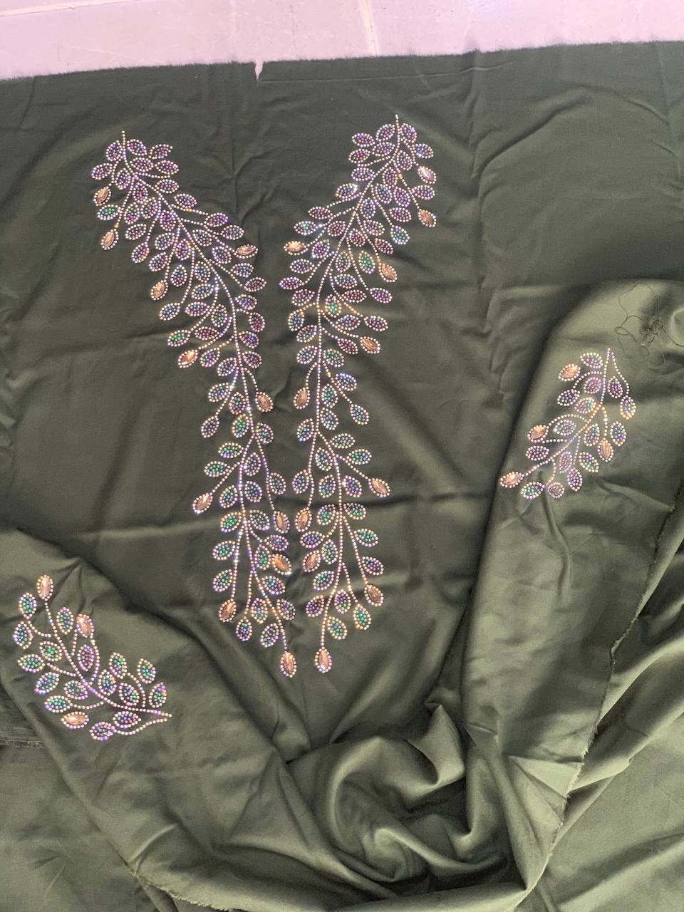 Intricate beadwork embroidery on dark green fabric — BRIQA craftsmanship