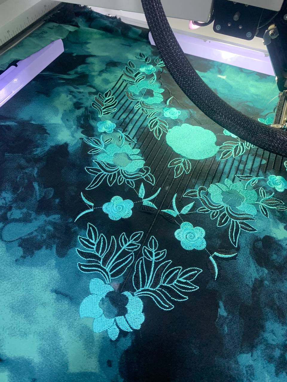 Teal floral machine embroidery close-up — BRIQA production